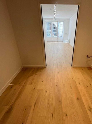 Perspective intérieure montrant deux pièces en enfilade avec un parquet en bois clair noueux posé par la menuiserie Jollivet de La Rochelle.