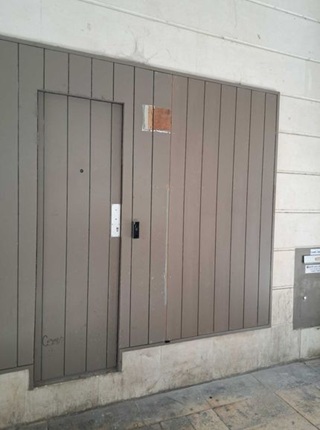 Façade en bois verticale avec porte de service dissimulée réalisée en rénovation pour le Crédit Mutuel à Chaniers