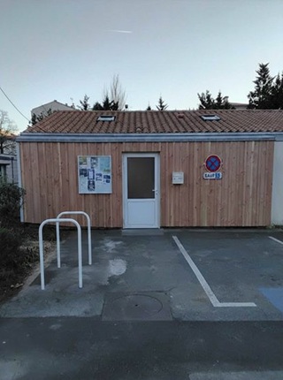 Vue de face du local technique avec son habillage en bois.