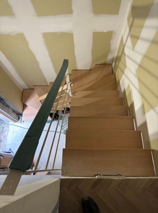 Escalier en bois de hêtre vernis installé dans un hôtel à la rochelle avec marches sur mesure et garde corps métal