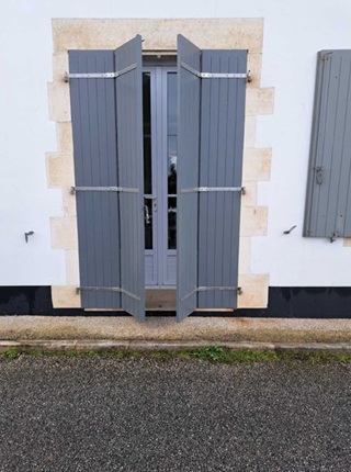 Volet battant en bois gris ouvert en papillon sur porte fenêtre à Périgny chantier neuf