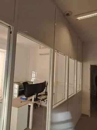 Cloison modulaire vitrée installée dans des bureaux à Saintes avec trois fenêtres intégrées et porte à âme pleine phonique dans un projet de rénovation d’aménagement