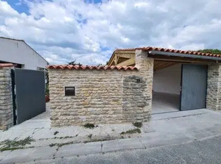 Portillon en aluminium gris ouvert à Lagord dans un projet de rénovation avec mur en pierre
