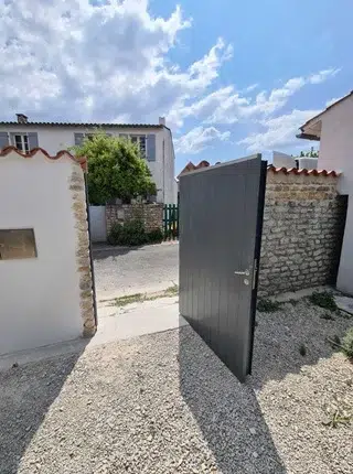 Vue intérieure d’un portail en aluminium gris posé à Lagord pour une rénovation résidentielle